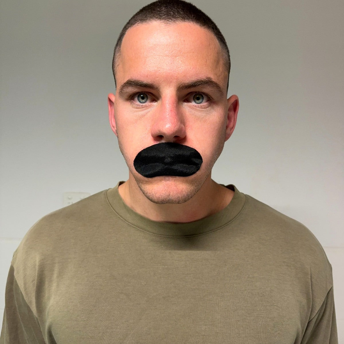 Real person wearing black mouth tape, front view